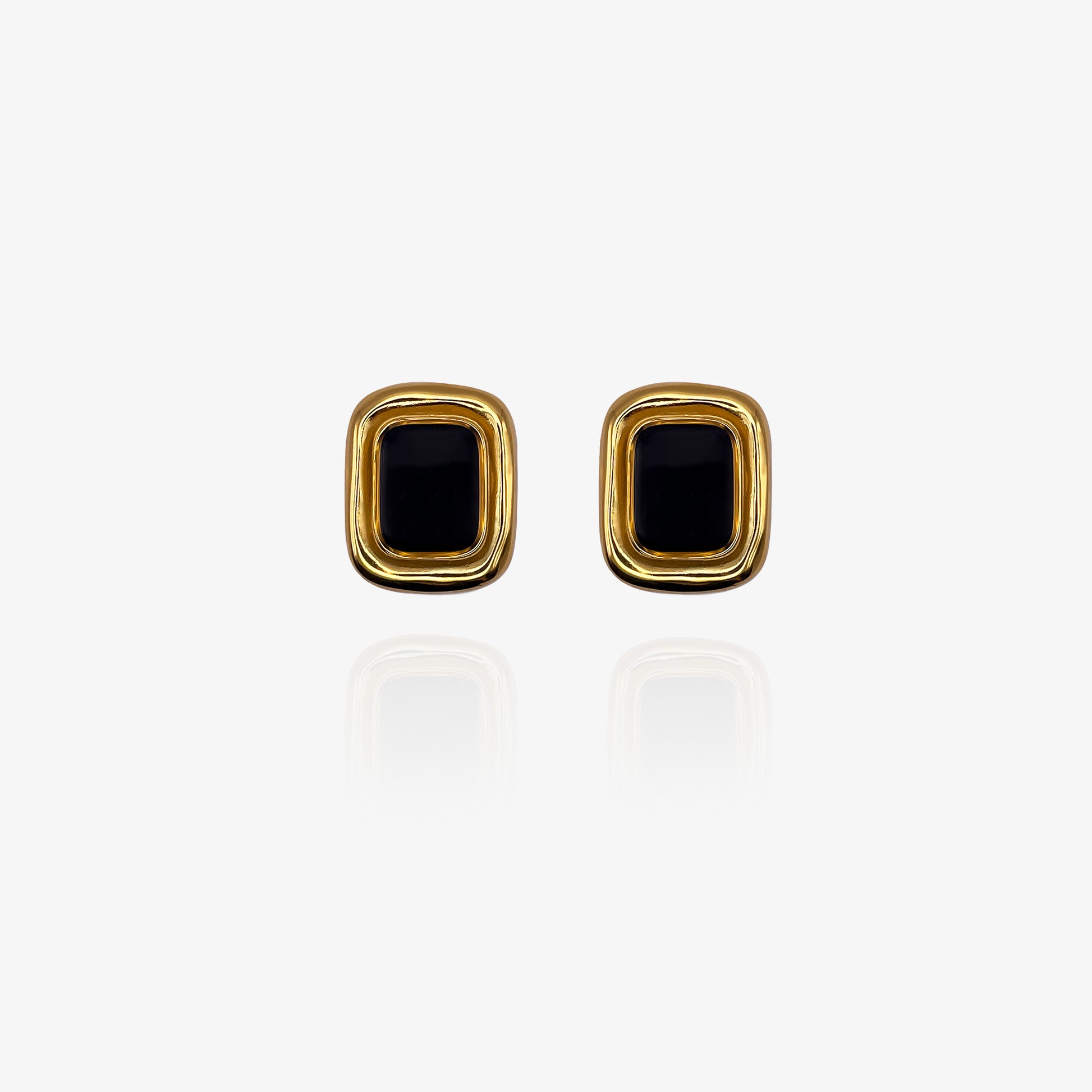 Gold earrings with black stones on a white background